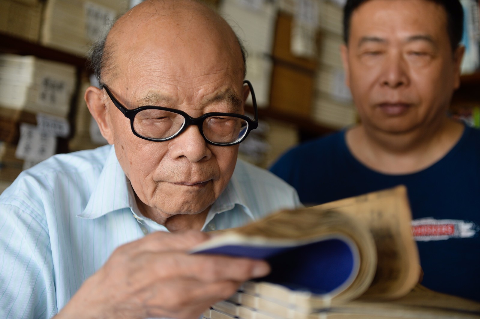    7月18日，江澄波老人在“文学山房”旧书店查看线装古书。 